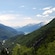 A verdant valley with snow capped mountains in the background